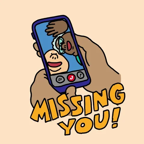 Someone holding a phone on a video call with two elderly people waving. The overlaid text reads: 'MISSING YOU!'