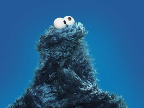 Cookie Monster scratching his head in confusion.