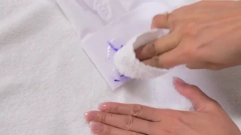A person removing a stain by blotting it.