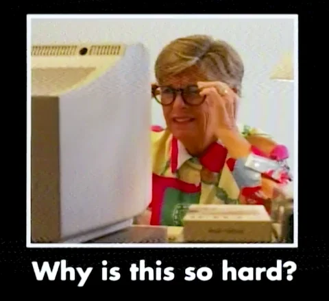 A woman shakes her head at a computer. The text reads: "Why is this so hard?"