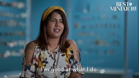  A woman wearing a floral print and a headband smiles and says, 