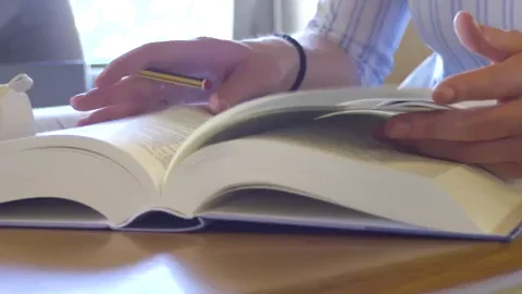 A person rapidly flipping pages in a book.