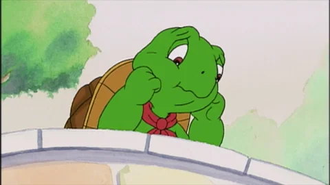 A green cartoon turtle looking sad.