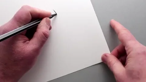 Left hand draws a circle while the right hand manipulates the paper.