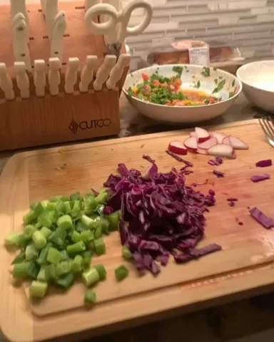 A person preparing tacos in a kitchen.