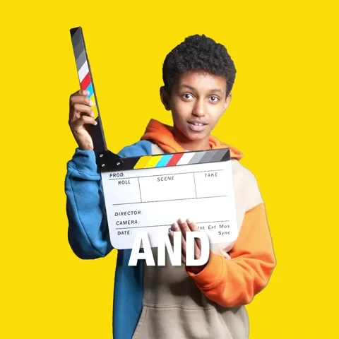 A teenager with a film production prop saying 'and action'.