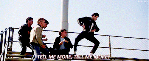 Dancers in the movie Grease singing 'tell me more, tell me more!'