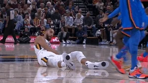 A basketball player helps a rival off the floor.