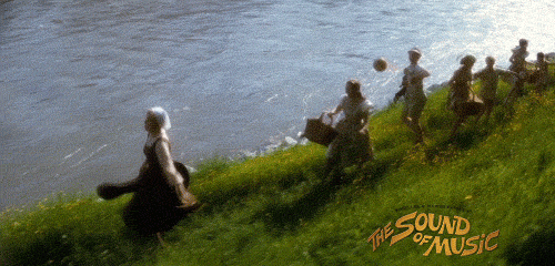 Maria from The Sound of Music running through grass with the Von Trapp children
