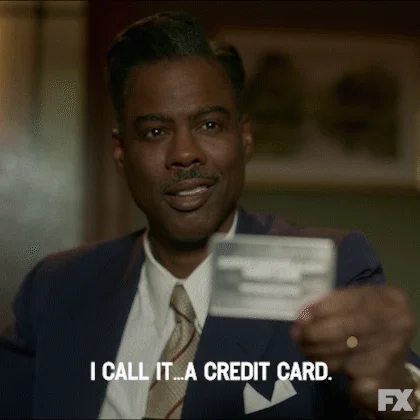 Chris Rock holding a credit card. He says, 