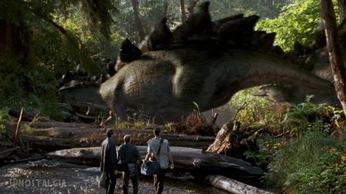 A scene from Jurassic park where three paleontologists look at dinosaurs moving through a jungle.