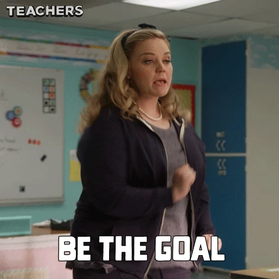 A teacher at the front of a classroom says, 'Be the goal, do the goal, become the goal.'
