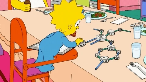Maggie from The Simpsons creating a scientific diorama with toys.