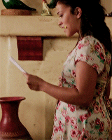 Gina Rodriguez (Jane the Virgin) looks at a document holding a highlighter in her mouth