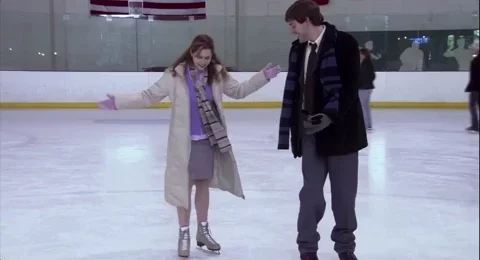 Jim and Pam from The Office skating at an ice rink.