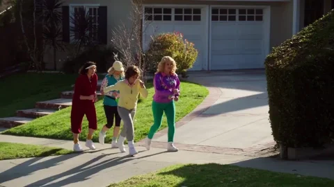 A group of women power walking through a suburban neighborhood.