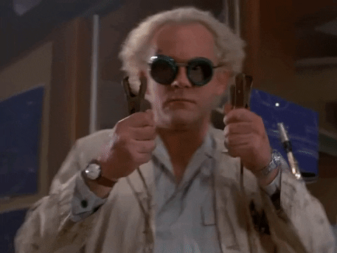 Doc Brown from Back to the Future holding two clamps & wearing goggles. He says, 