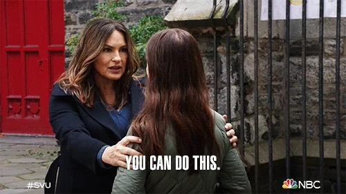 An older woman holding a younger female by her shoulder, arms length away, and telling her, 