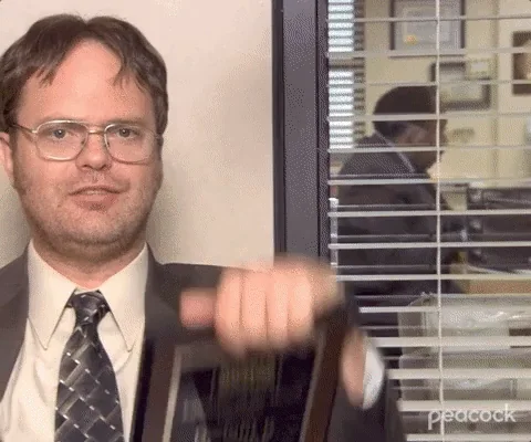 Dwight Schrute holding Employee of the Month plaques