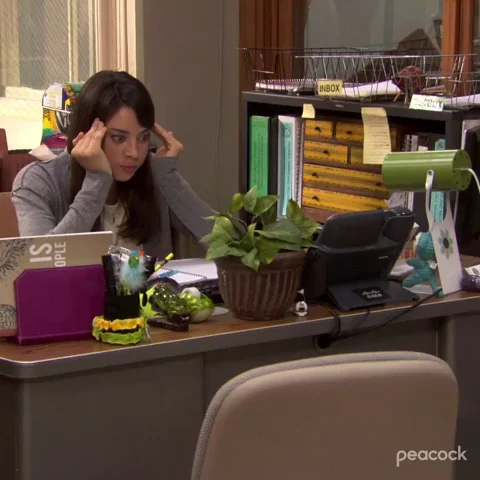 A girl is sitting at her desk with a stressed look on her face. 