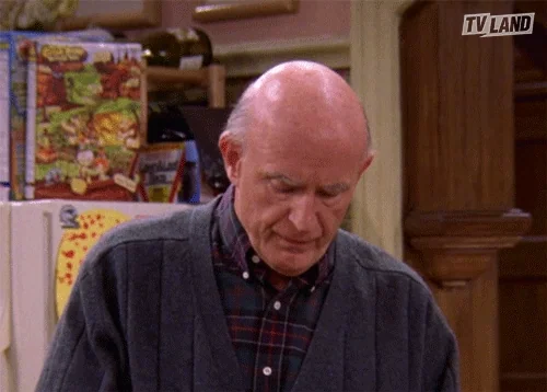 An old man eats yogurt.