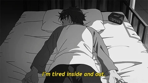 An anime character lying face down in bed. He says, 'I'm tired inside and out.'