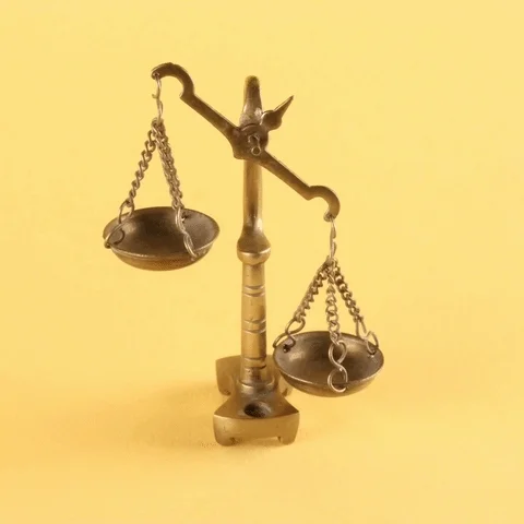 A libra scale out of balance. A finger pushes on the scale to set it back to a balanced position.