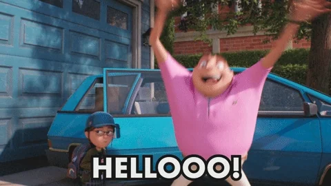 A man in a driveway waving both hands and saying hello to a neighbor.