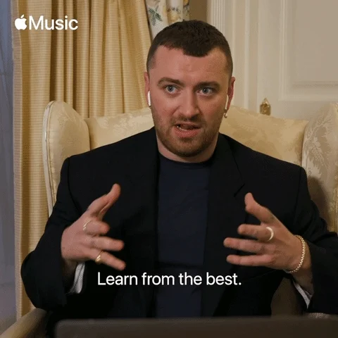 Artist Sam Smith sitting in a chair during an interview while saying, 