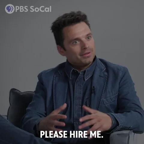 A man smiles and says, "Please hire me."