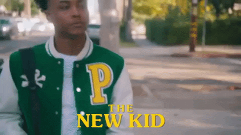 A person walking down the street behind the text 'the new kid'