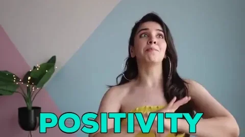 A smiling woman, gesturing with her hands while saying, 