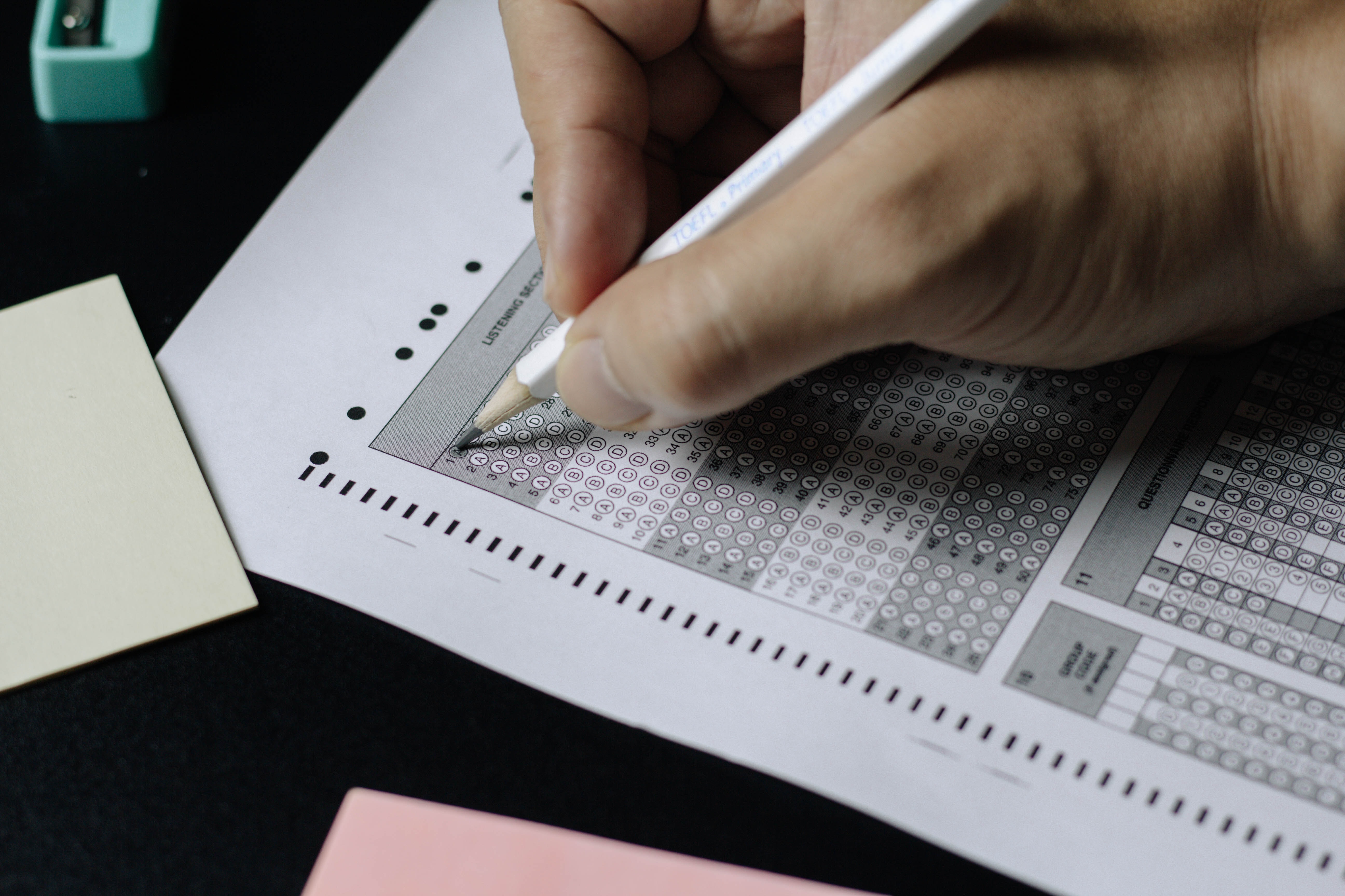 A student filling outa scantron answer sheet during a summative assessment.