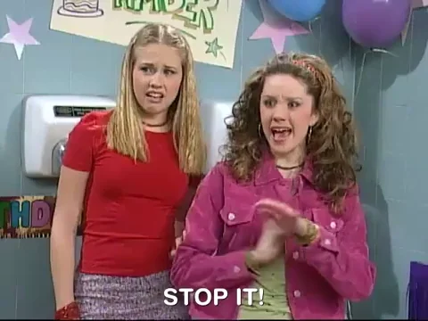 Two girls in a high school bathroom. One says, 