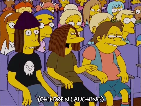 A group of Simpsons teenagers laughing at a school assembly.