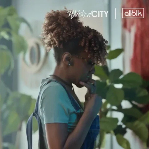 A woman pacing around and looking nervous, chewing her nails.