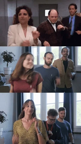 Seinfeld characters dancing, while two work teams dance along in a split screen.