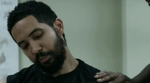 A person helping a man remedy their shoulder pain.