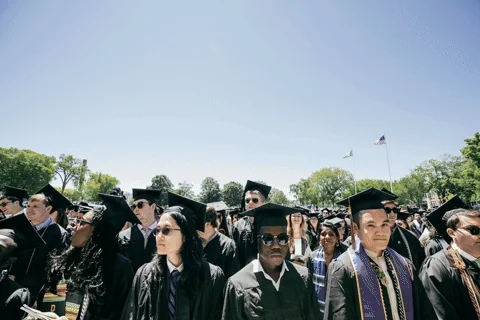 Students tossing their graduation caps into the air at a ceremony.