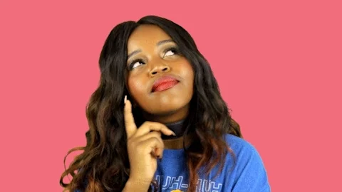 A woman tapping on her cheek in tought.