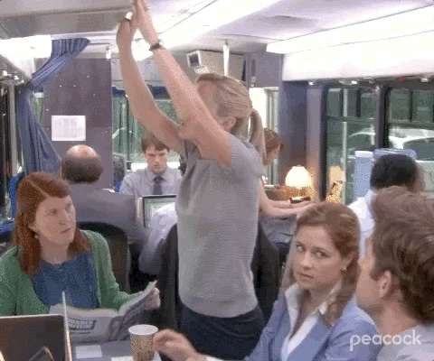 A scene from The Office. Multiple papers fall down on top of an employee. 