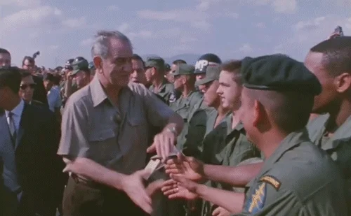 President Johnson shakes hands with American soldiers.
