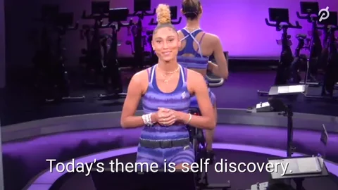 A workout coach on an exercise bike says, 'Today's theme is self discovery.'