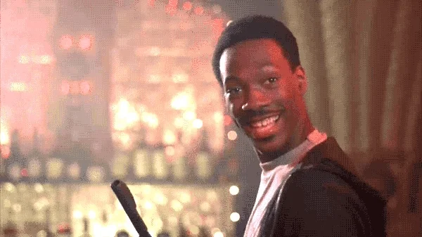 Eddie Murphy smiles and gives the ok sign with his hands.