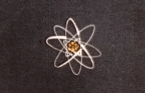 An old instructional film depicting an atomic structure.