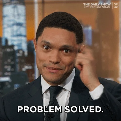 Trevor Noah tapping forehead and pointing at the audience, mouthing 