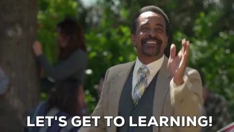 A man claps his hands once and begins walking forward with a confident stride, saying "Lets get to lLearning!"