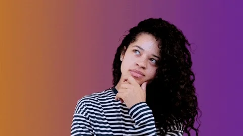 A GIF of a woman with long, black curly hair thinking.