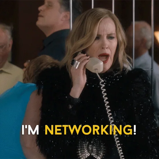 Moira Rose from Schitt's Creek talks on the phone during a party and says, “I’m networking!”