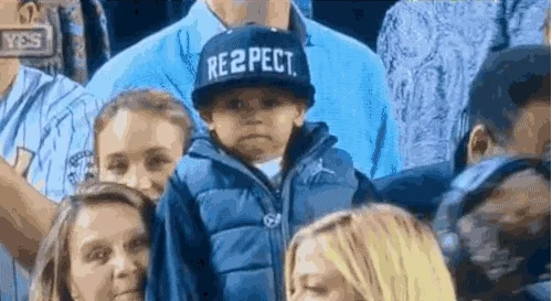A young boy removes baseball cap that reads 'Respect'.